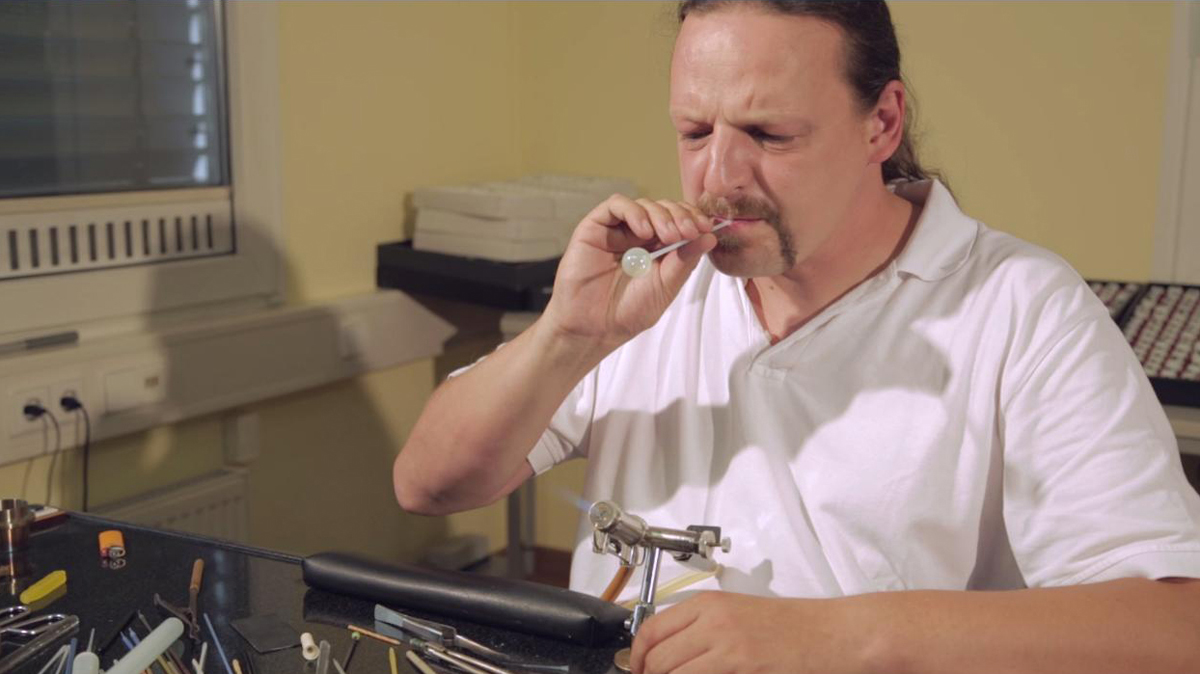 Conny Urban bläst einen Hohlkörper für eine künstliche gläserne Augenprothese
